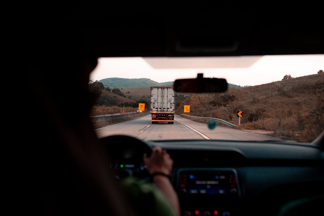 Scenic drive with a truck on a highway surrounded by hills. Perfect for travel themes.
